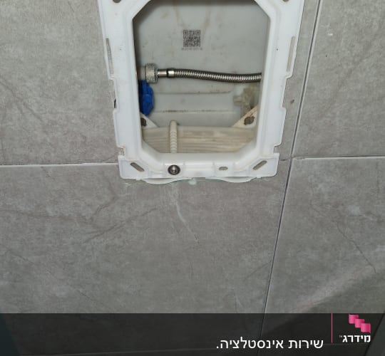 תמונה של חיבור צנרת בקיר חדר אמבטיה
